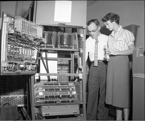 Employees using an old IBM computer